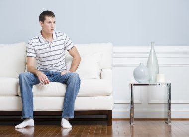 Man Sitting on Living Room Couch clipart