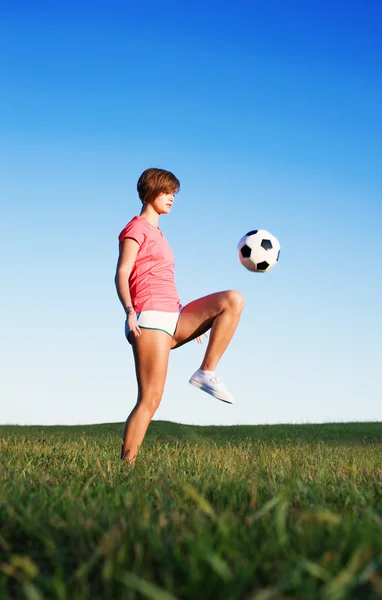Mladá žena hrát fotbal — Stock fotografie