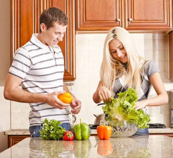 Giovane coppia rendendo insalata — Foto Stock