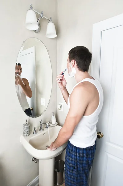 Hombre joven en el baño de afeitar —  Fotos de Stock