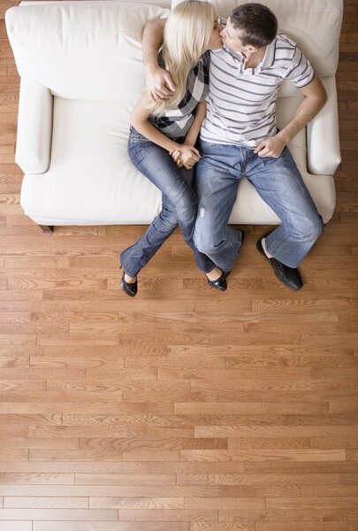 Young Couple Sitting on Love Seat Kissing