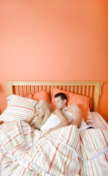 若いカップルがベッドで寝ていて — ストック写真
