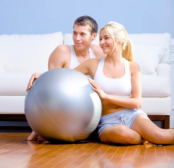 Couple Sitting on Floor With Silver Exercise Bal — Stock Photo, Image
