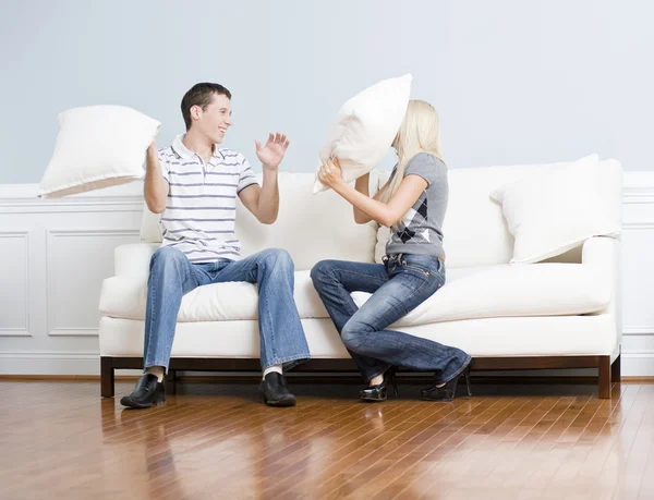 Young Couple Having a Pillow Fight on Sofa — Stock Photo, Image