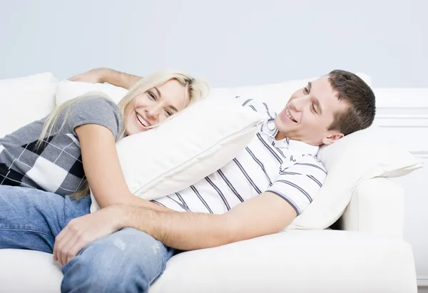 斜躺在沙发上的年轻夫妇 — 图库照片