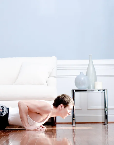 Hombre haciendo flexiones en la sala de estar — Foto de Stock