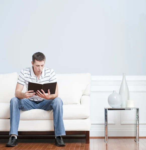 Чоловік читає на дивані вітальні — стокове фото