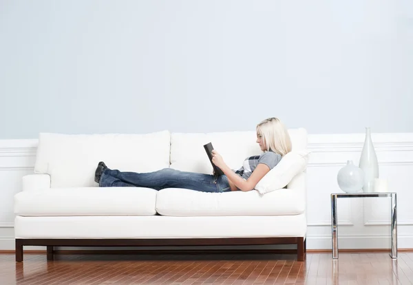 Γυναίκα ξαπλωμένος στον καναπέ με το βιβλίο — Φωτογραφία Αρχείου