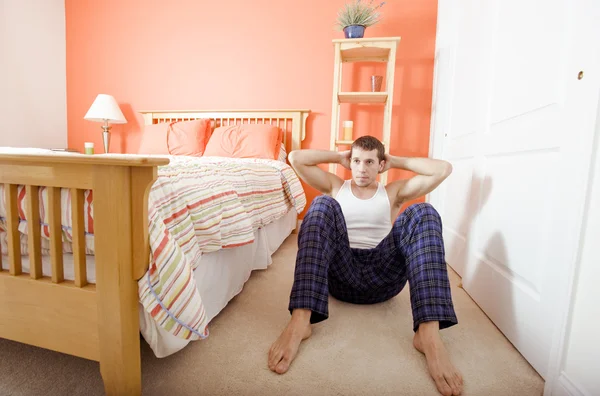 Mann macht Sit-ups im Schlafzimmer — Stockfoto