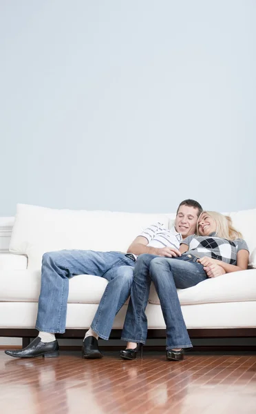Прихильна пара сміється і розслабляється на дивані — стокове фото
