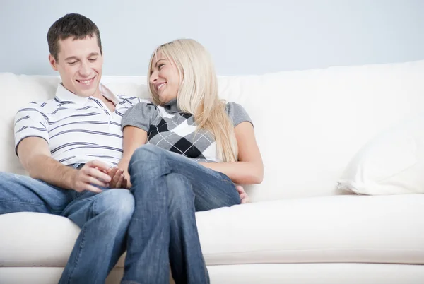 Прихильна пара сміється і розслабляється на дивані — стокове фото