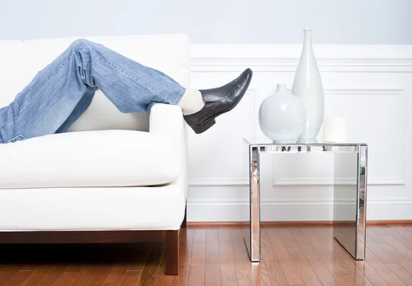 Pernas do Homem Reclinando no Sofá Branco — Fotografia de Stock