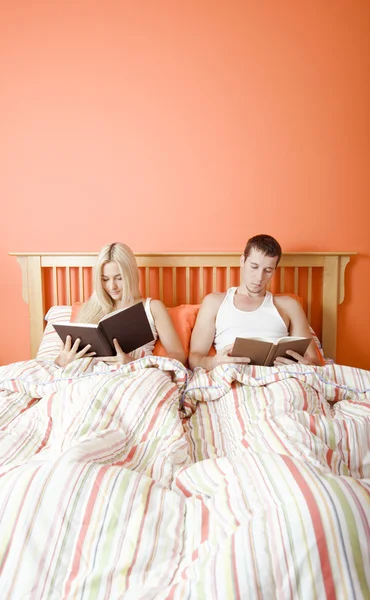 Leitura de casal na cama — Fotografia de Stock