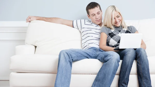 Casal feliz relaxante no sofá — Fotografia de Stock