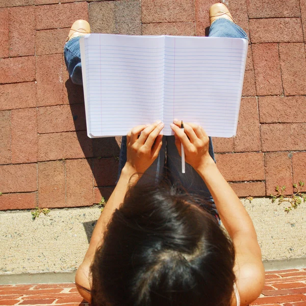 Chica escribiendo en el libro de notas — Foto de Stock