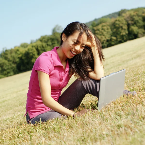 Menina no laptop no prado — Fotografia de Stock