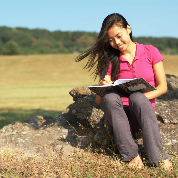 Dziewczyna pisze w książce — Zdjęcie stockowe