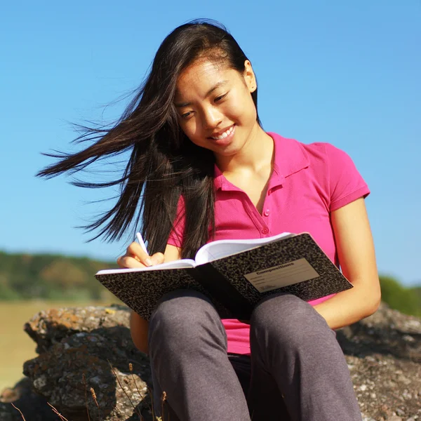 Dziewczyna pisze w książce — Zdjęcie stockowe