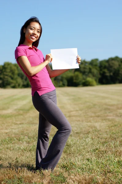 Girl with blank sign in field — Stock Photo, Image