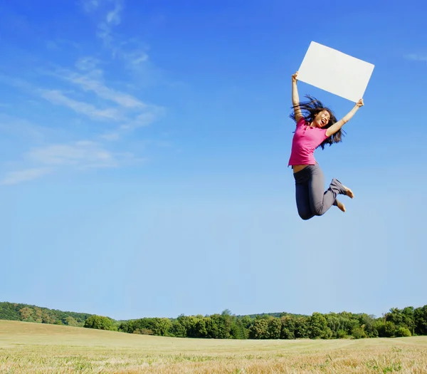 Mädchen springt mit Schild — Stockfoto