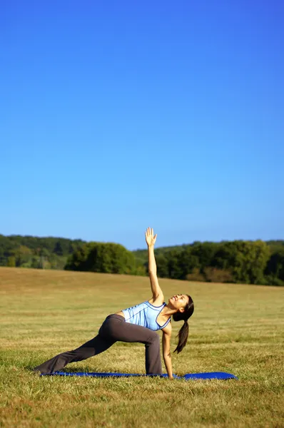 Девушка практикует йогу в поле — стоковое фото
