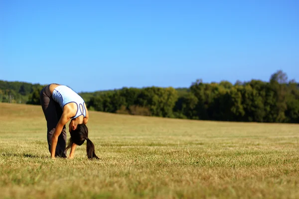 Chica practicando yoga en el campo — Foto de Stock