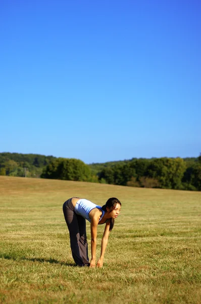 Dívka cvičení jógy v oboru — Stock fotografie