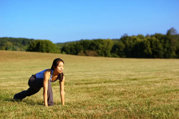 Mädchen praktiziert Yoga im Feld — Stockfoto
