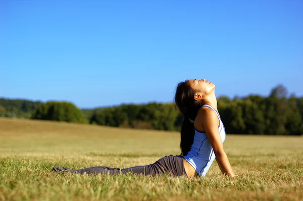 Flicka praktisera yoga i fältet — Stockfoto
