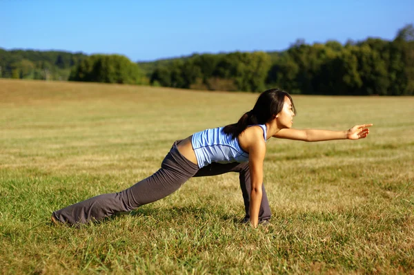 Mädchen praktiziert Yoga im Feld — Stockfoto