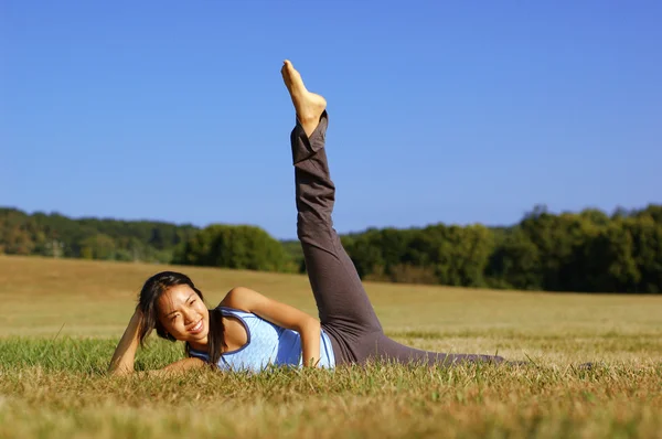 Dívka cvičení jógy v oboru — Stock fotografie