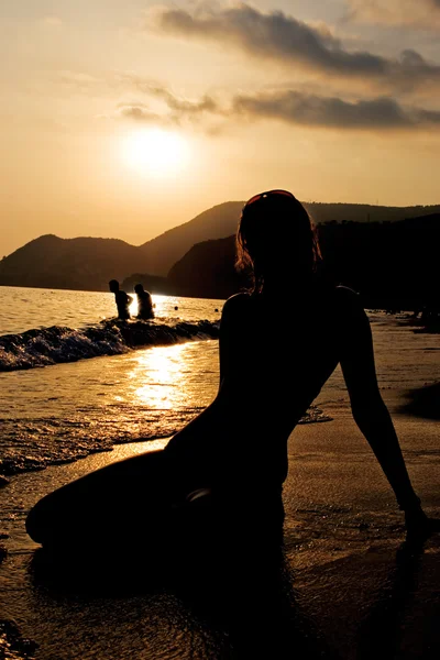 Silhueta de uma menina em uma praia — Fotografia de Stock