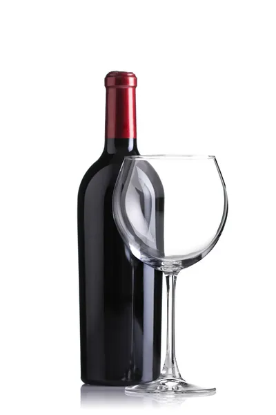 Garrafa de vinho tinto e um copo vazio — Fotografia de Stock