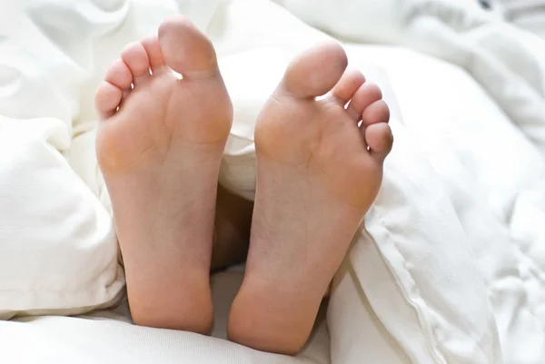 Zwei Beine im Bett — Stockfoto