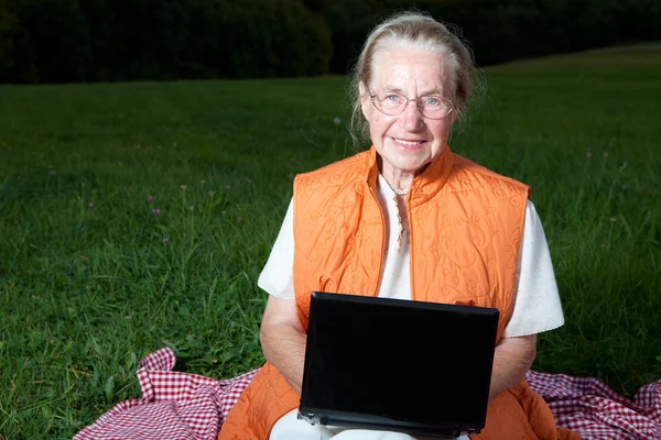 Donna anziana utilizzando un computer portatile — Foto Stock