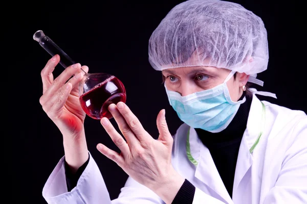 Científica femenina examinar frasco —  Fotos de Stock