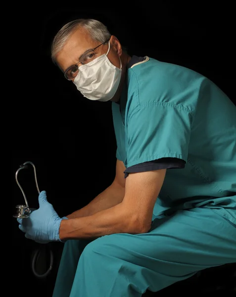 Médico de mediana edad sentado sobre negro —  Fotos de Stock