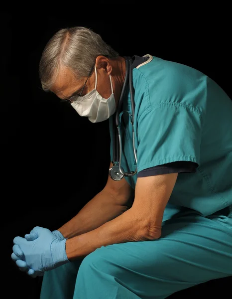 Arzt mittleren Alters sitzt über schwarz — Stockfoto