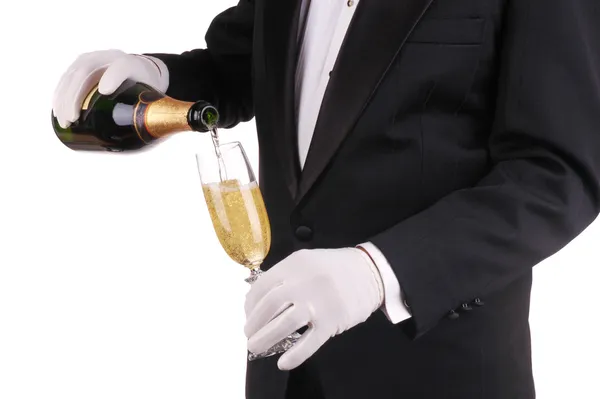 Человек в смокинге разливает шампанское — стоковое фото