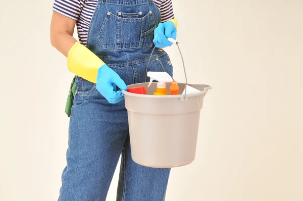 Femme en salopette avec des fournitures de nettoyage — Photo