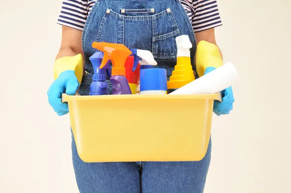 Женщина в комбинезоне с чистящими средствами — стоковое фото