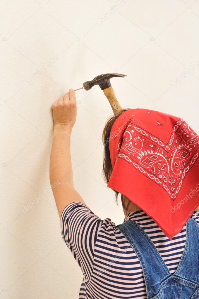 Woman in Overalls Hammering Nail