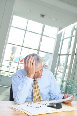 Businessman Reading Newspaper at Desk clipart