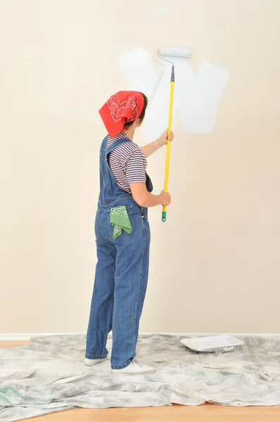 Kvinna i overaller måla vägg — Stockfoto