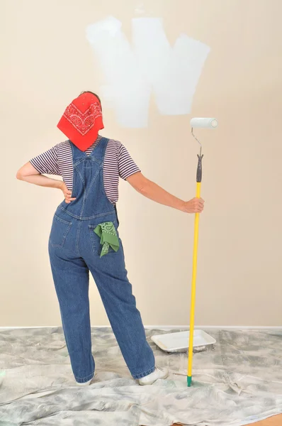 Kvinna i overaller håller paint roller — Stockfoto