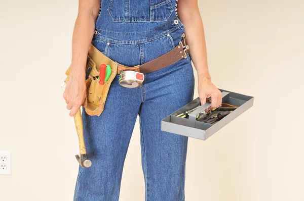 Femme en salopette avecplateau à outils — Photo
