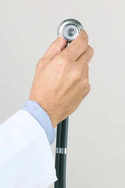 Läkare hand som håller upp ett stetoskop — Stockfoto