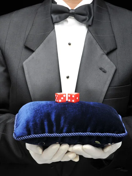 Mayordomo con almohada de terciopelo y dados rojos — Foto de Stock