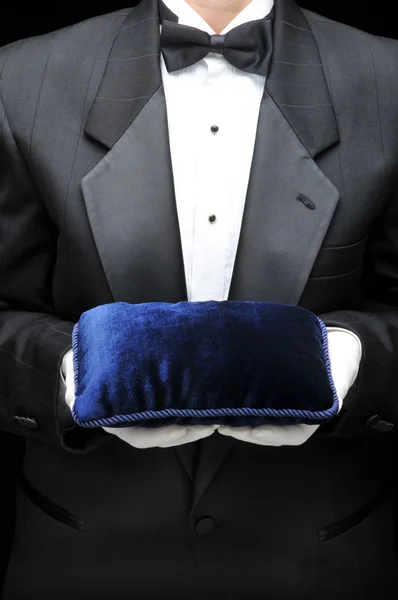 Butler avec oreiller en velours dans ses mains — Photo