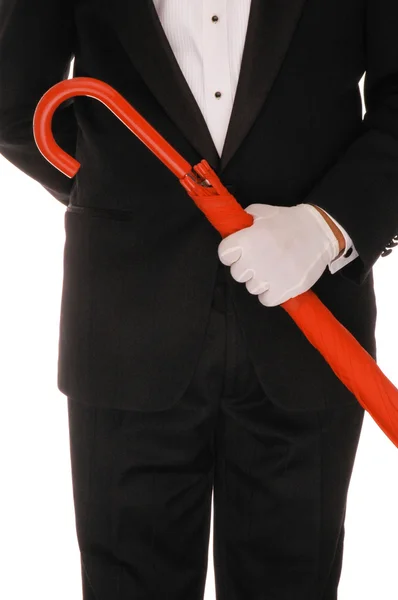 Человек в смокинге с красным зонтиком — стоковое фото